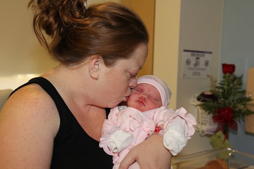 Mother Tiffany cradles the first newborn in Kings County in 2017, Shaylee. The birth occurred in the Adventist Medical Center's Family Birth Center.